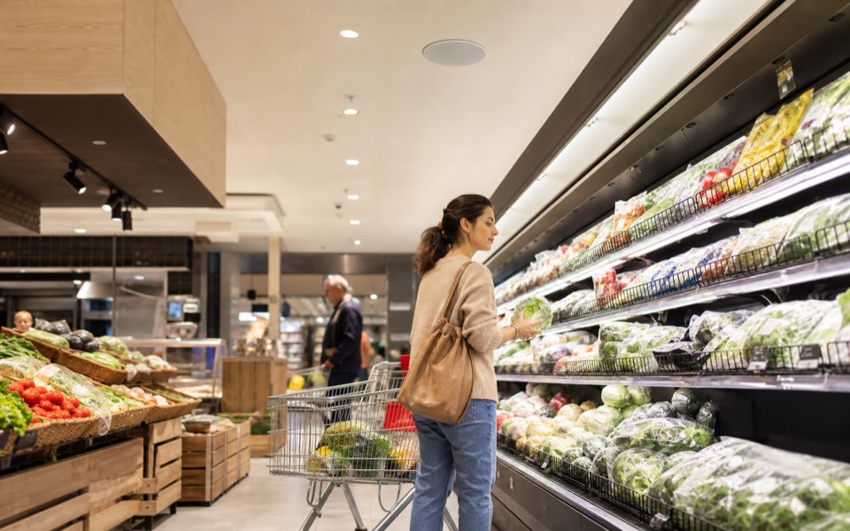 corsia luminosa di un supermercato reale con clienti durante la spesa